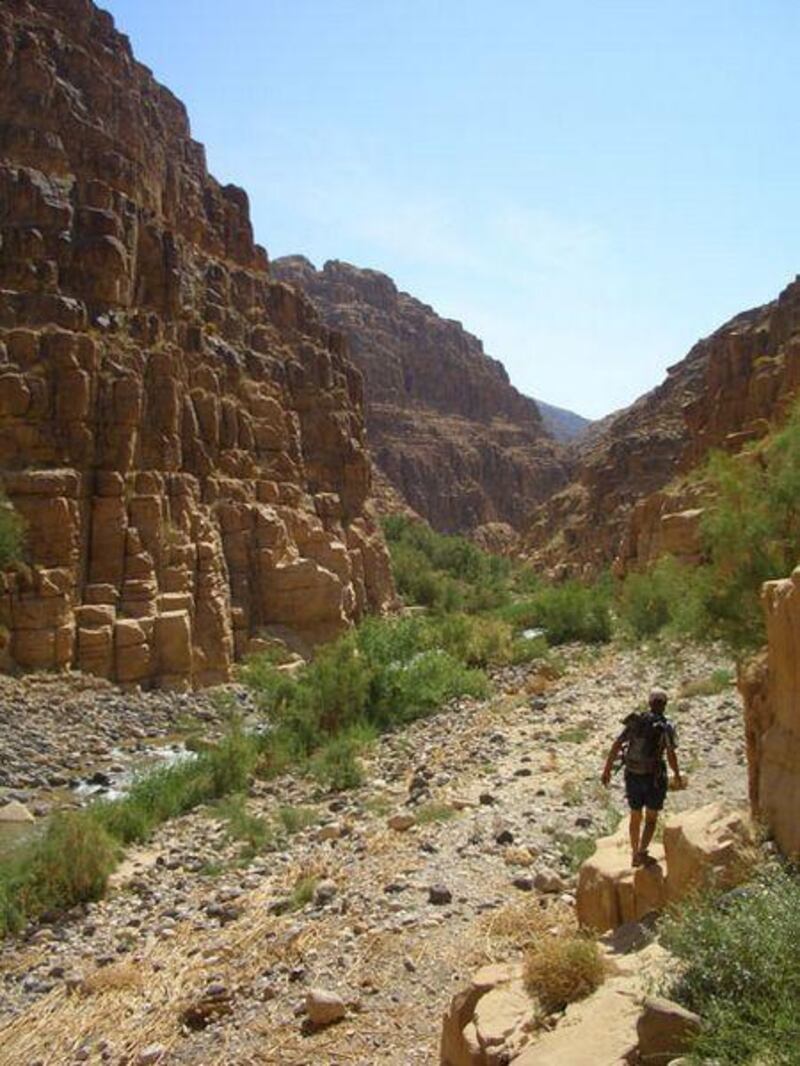 A hiker negotiates the stony path on the nine-hour trail from Feynan.