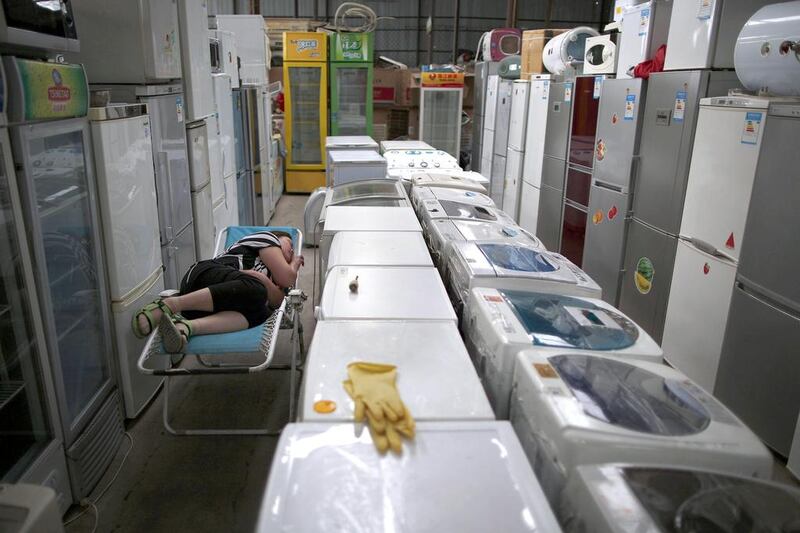 A woman sleeps in a shop which sells recycled electronic goods at Yaojiayuan village in Beijing. Kim Kyung-Hoon / Reuters