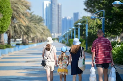 Families enjoying their time outdoors along the Corniche in Abu Dhabi. The UAE's family law is intended to send residents a message that they should feel comfortable building a life, a family and a home here. Khushnum Bhandari / The National