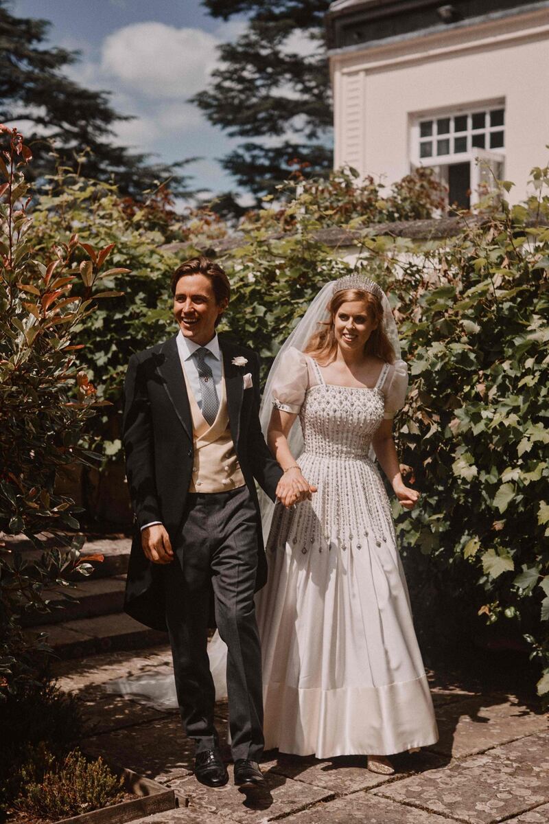 Britain's Princess Beatrice and her husband Edoardo Mapelli Mozzi in the grounds of the Royal Lodge, Windsor, on July 17, 2020 after their marriage ceremony. The bride wore a vintage gown, borrowed from her grandmother, Queen Elizabeth II. The Norman Hartnell dress, made from taffeta, organza and satin, and encrusted with diamante, was worn by the monarch in 1962. AFP