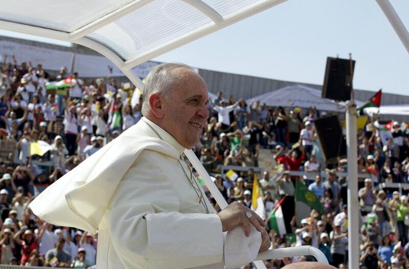 Pope Francis greets the crowd before celebrating a mass at the Amman stadium in the Jordanian capital on May 24, 2014. Pope Francis made an urgent plea today for peace in war-torn Syria as he kicked off a three-day pilgrimage to the Middle East. AFP PHOTO / KHALIL MAZRAAWI (Photo by KHALIL MAZRAAWI / AFP)