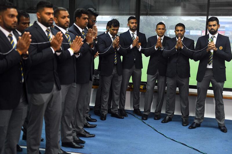 Sri Lanka's cricket captain Lahiru Thirimanne (R) and teammates look on as Buddhist monks chant prayers for their success during a ceremony in Colombo on Septemer 24, 2019, prior to the team's departure for a cricket tour in Pakistan. Sri Lanka's cricket board on September 19 said it will go ahead with its tour of Pakistan despite fears that players could be the targets of terror attacks during the six-match visit. / AFP / ISHARA S. KODIKARA
