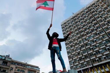 A Lebanese demonstrator waves the national flag during a protest in Beirut. AFP