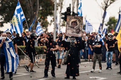 Protesters hold Greek flags and an icon  during a demonstration against the agreement reached by Greece and Macedonia to resolve a dispute over the former Yugoslav republic's name, during the opening of the 83rd Thessaloniki International Fair (TIF), on September 8, 2018 in Thessaloniki. (Photo by ARIS MESSINIS / AFP)