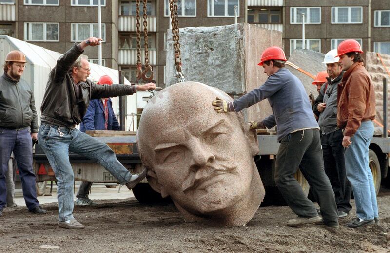 TO GO WITH AFP STORY by ELOI ROUYER - FILES - A photo dated November 13, 1991, shows workers removing the head of a statue representing late Soviet leader Vladimir Ilyich Lenin during its demolition on the Leninplatz in Berlin. The 19-meter-tall (62-foot-tall) statue of the Russian revolutionary was sawed from its pedestal in the Friedrichshain district of east Berlin in 1991, one year after German reunification, and buried near the Mueggelsee lake in nearby Koepenick. The enormous statue -- immortalized in the hit German film "Good Bye Lenin" -- was erected in 1970, shortly before the 100th anniversary of Lenin's birth. 
AFP PHOTO / DPA / BERND SETTNIK +++ GERMANY OUT (Photo by BERND SETTNIK / DPA / AFP)