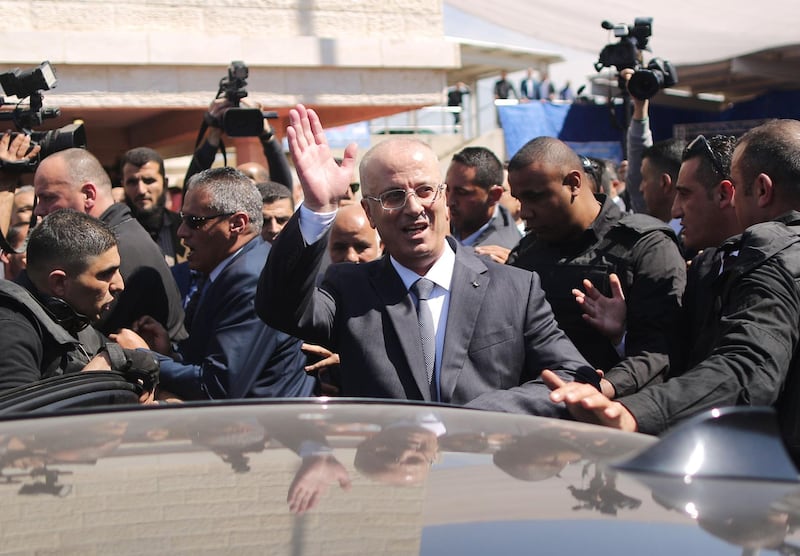 Palestinian Prime Minister Rami Hamdallah waves to the crowd upon his arrival in Gaza City on March 13, 2018. Hamdallah cut short a rare visit to Gaza on Tuesday after an explosion targeted his convoy, a source in the delegation said. The premier, who was not hurt, left the Hamas-run territory through the Erez crossing shortly after opening a wastewater treatment facility, the source said.  Mahmud Hams / AFP