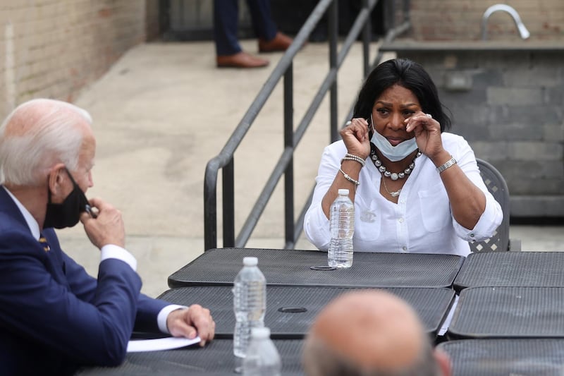 Democratic U.S. presidential candidate and former Vice President Joe Biden listens to Carlette Brooks as she wipes away tears and talks about the effects of the coronavirus disease (COVID-19) pandemic on her family and their small businesses on the outside patio of the Carlette’s Hideaway sports bar during a campaign stop in Yeadon, Pennsylvania U.S., June 17, 2020. REUTERS/Jonathan Ernst