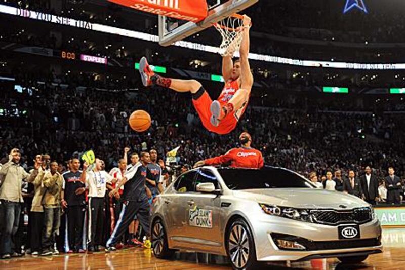 Blake Griffin from the LA Clippers slam dunks over a car with teammate Baron Davis inside.