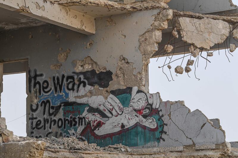 A mural on the wall of a destroyed school in Sarmin. The slogan refers to the Syrian government considering all rebels terrorists. AFP
