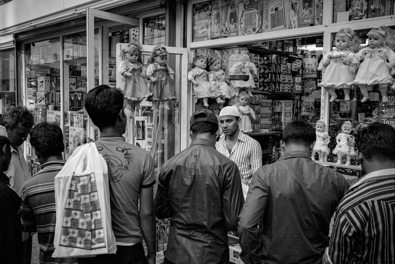 A merchant faces a wall of customers outside his shop in downtown Abu Dhabi on the first Friday in the month of April. With monthly pay cycles, Fridays bring out large crowds often shopping for gifts to send home to family. Brian Kerrigan / The National