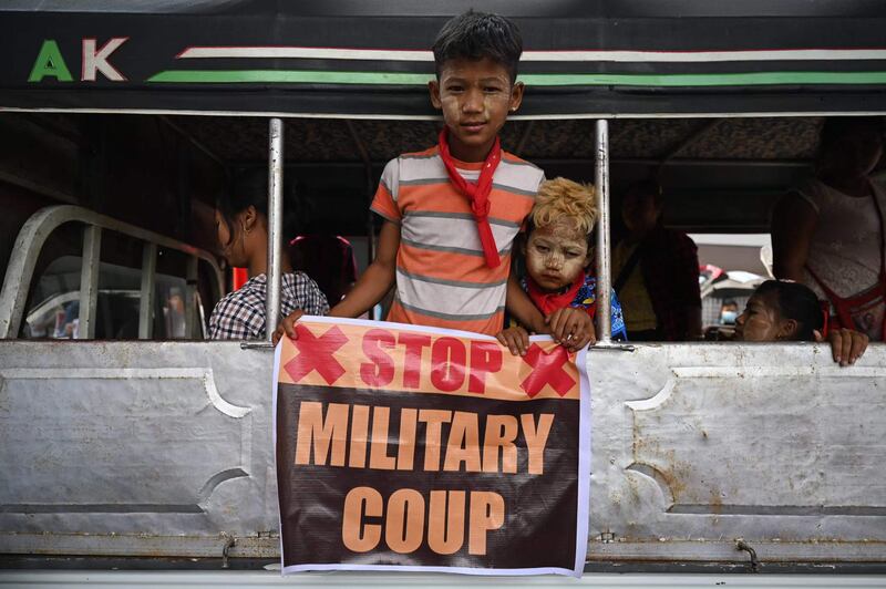 Young protesters hold a sign during a demonstration against the military coup in Yangon. AFP