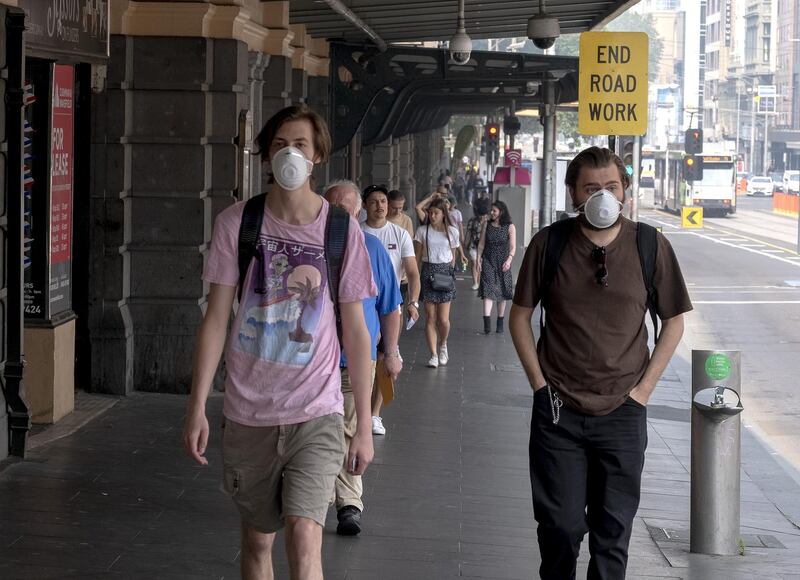 Melbourne commuters walk wearing a mask as the city suffers hazardous air quality in Melbourne, Australia. Getty