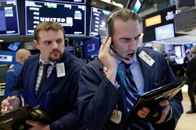 Traders Michael Milano, left, and Gregory Rowe work on the floor of the New York Stock Exchange just before the closing bell, Wednesday, April 4, 2018. After plunging 501 points at the open, the Dow Jones industrial average finished with a gain of 230 points, or about 1 percent. (AP Photo/Richard Drew)