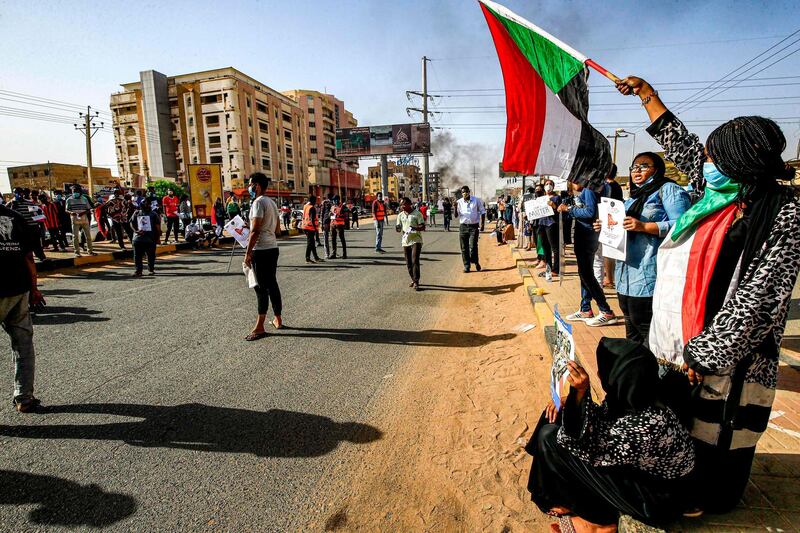 Sudanese protesters, some clad in masks as a precaution due to the coronavirus pandemic, gather to mark the first anniversary of a raid on an anti-government sit-in, in the Riyadh district in the east of the capital Khartoum.  AFP