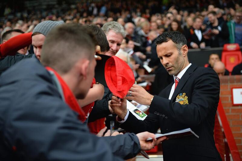 Giggs signs autographs for supporters before the start of the game. Laurence Griffiths / Getty Images