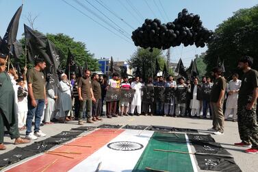 Kashmiris raise black flags above the Indian national flag in Muzaffarabad to protest New Delhi's move to revoke the special status of Jammu and Kashmir. EPA
