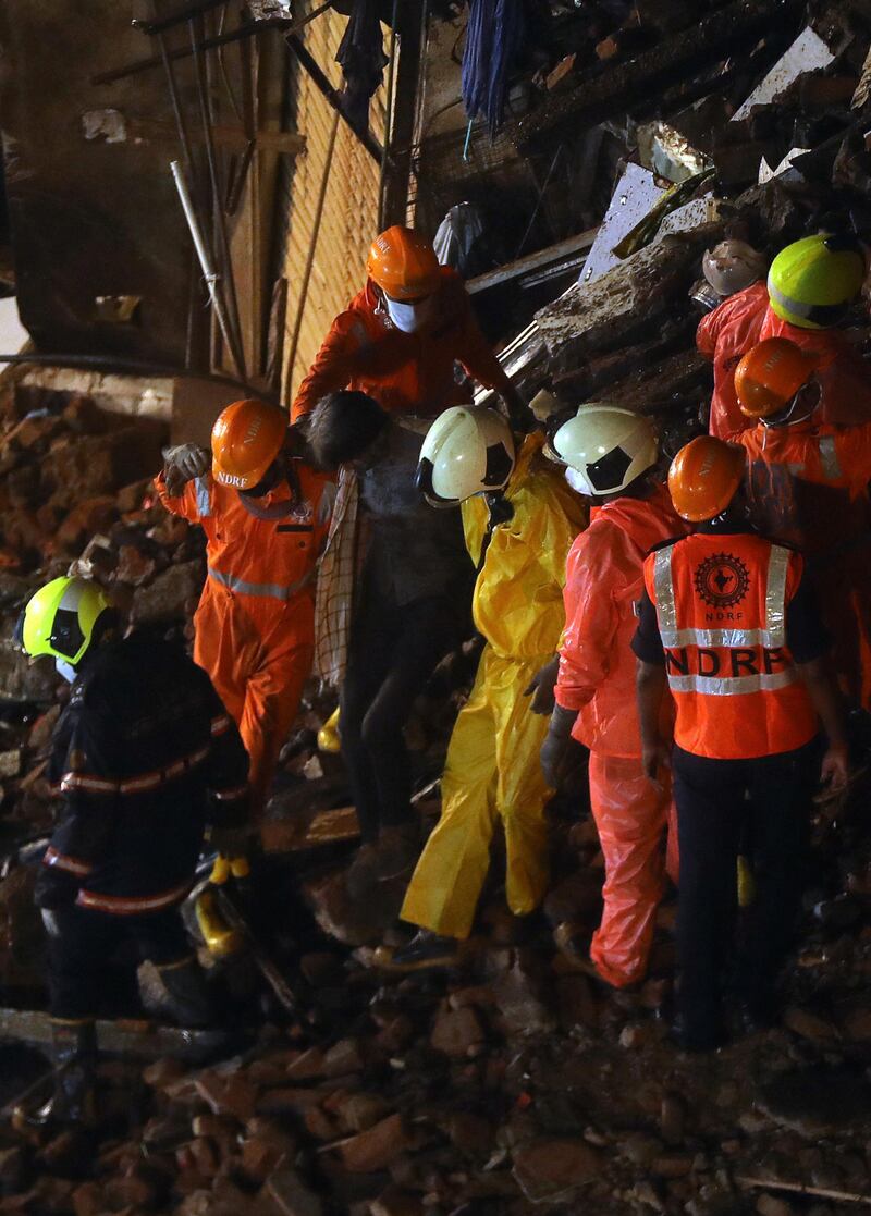 Rescuers help a man rescued from the rubble after the partial building collapse in south Mumbai. Reuters