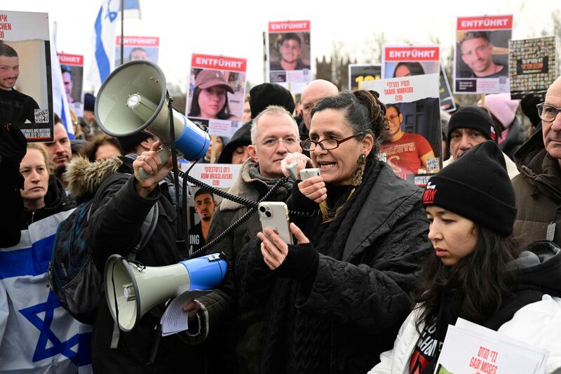 Efrat Machikawa takes to the megaphone next to Aya Machikawa, right, in Berlin to demand the freedom of their relative, Hamas hostage Gadi Moses, on January 14. AFP