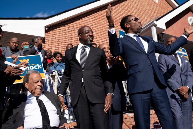 Mr Warnock prepares to speak at a rally after being introduced by civil rights activist Andrew Young, seated, and Atlanta Mayor Andre Dickens in November. AP