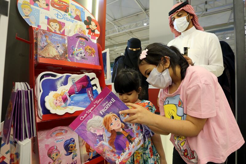 Girls look at children's books at the month-long fair.