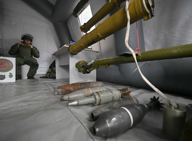 An officer from National Guard of Ukraine surveys weapons left behind by Russian troops in Chernobyl. AFP
