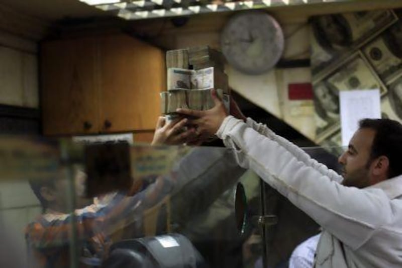 Egypt's foreign currency reserves dipped below $14 billion last month, the IMF's recommended level that covers three months of imports. Khalil Hamra / AP Photo