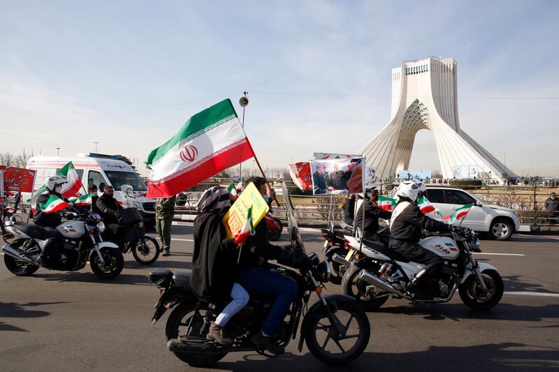 epa09000597 Iranians wave the country's national flags during a rally marking the 42nd anniversary of the 1979 Islamic Revolution, at the Azadi (Freedom) square in Tehran, Iran, 10 February 2021. The event marks the 42nd anniversary of the Islamic revolution, which came ten days after Ayatollah Ruhollah Khomeini's returned from his exile in Paris to Iran, toppling the monarchy system and forming the Islamic Republic.  EPA/ABEDIN TAHERKENAREH