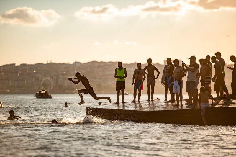 People jump into the Sea of marmara during sunset in Istanbul, Turkey.   AFP