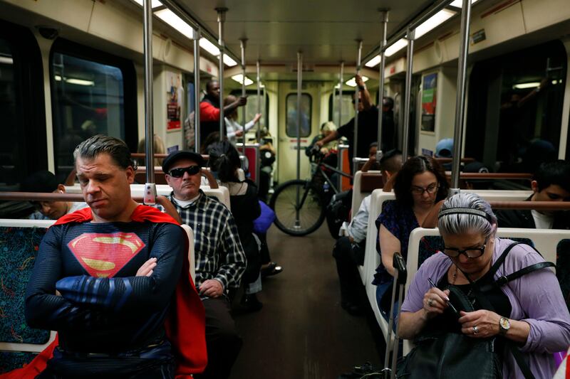 Superhero impersonator Justin Harrison, left, rides a Metro train wearing a Superman costume on his way to Hollywood Boulevard in Los Angeles. "I always go out in a costume," said Harrison. "I love seeing people happy and seeing them smile." Jae C Hong / AP Photo