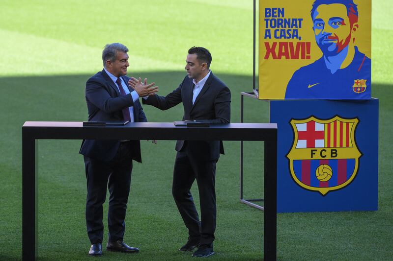 Xavi Hernandez and Joan Laporta shake hands during the presentation ceremony at Camp Nou. AFP
