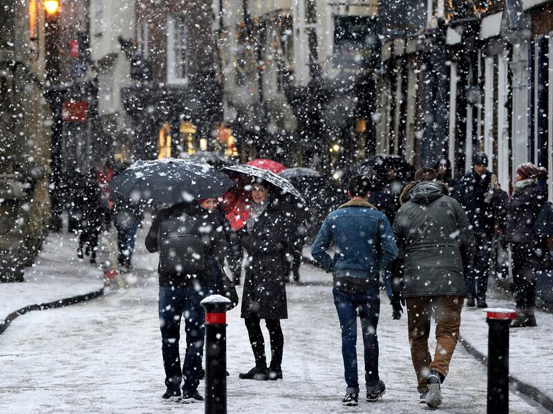 People walk through the snow in York, England. John Giles/PA via AP