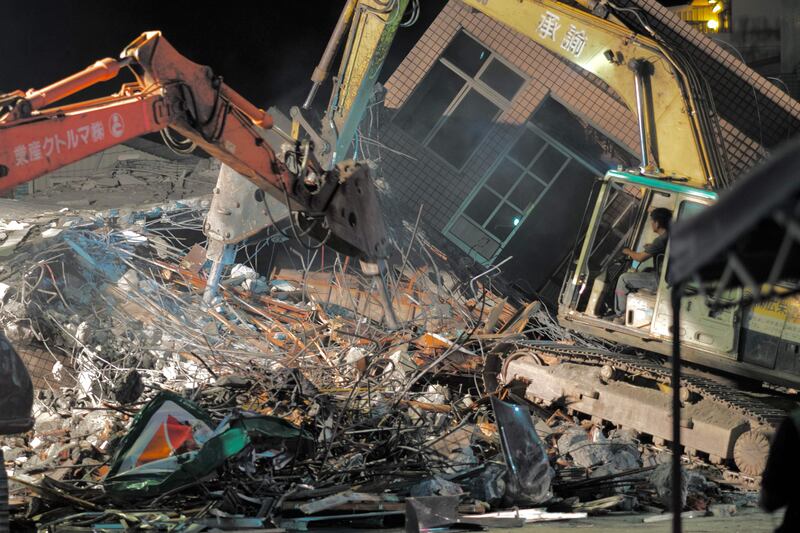 Workers use cranes to take down a collapsed building in Yuli township. AFP