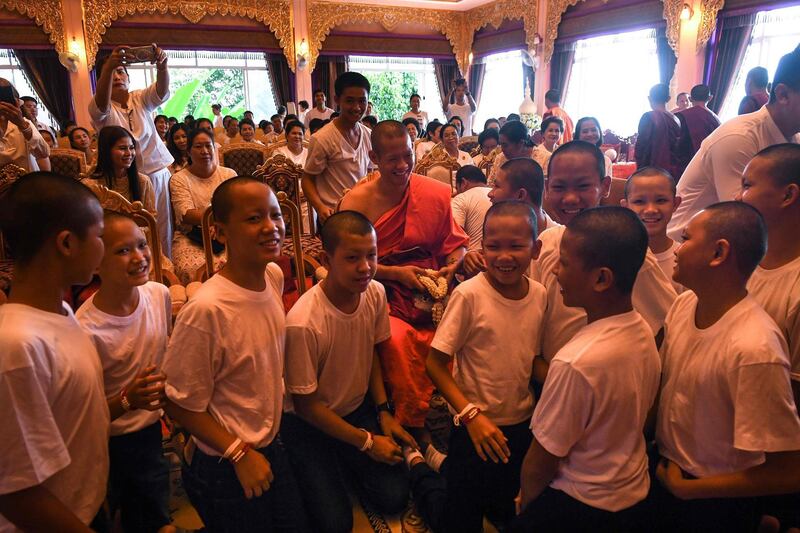Chantawong is surrounded by the 11 members of the Wild Boars football team after the ceremony. AFP