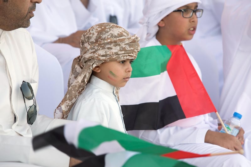 ZAYED MILITARY CITY, ABU DHABI, UNITED ARAB EMIRATES - November 28, 2017: A young guest watches the parade during the graduation ceremony of the 8th cohort of National Service recruits and the 6th cohort of National Service volunteers at Zayed Military City. 

( Boris Dejanovic for the Crown Prince Court - Abu Dhabi  )
---
