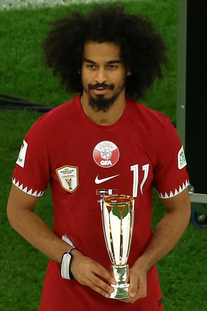 Qatar forward Akram Afif celebrates with the Most Valuable Player Award trophy. AFP