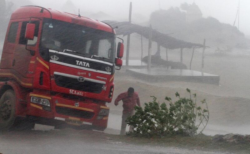 A truck driver takes shelter during rain and strong winds caused by Cyclone Titli. AP Photo