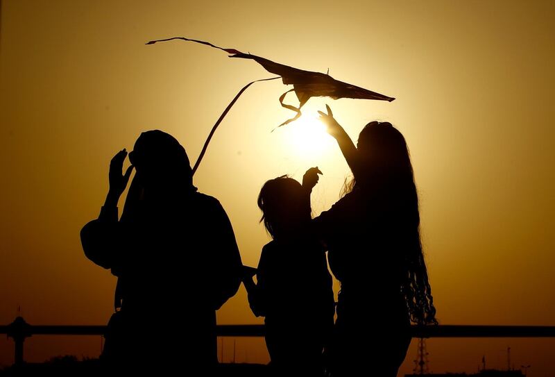 People take part in the Baghdad Kite Festival as the sun sets in Baghdad, Iraq, Saturday, June 5, 2021. (AP Photo/Hadi Mizban)
