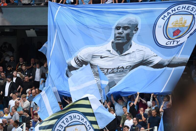 Supporters hold up a banner in honour of Manchester City's Belgian defender Vincent Kompany ahead of the English Premier League football match between Manchester City and Newcastle United at the Etihad Stadium in Manchester, north west England, on September 1, 2018. (Photo by Oli SCARFF / AFP) / RESTRICTED TO EDITORIAL USE. No use with unauthorized audio, video, data, fixture lists, club/league logos or 'live' services. Online in-match use limited to 120 images. An additional 40 images may be used in extra time. No video emulation. Social media in-match use limited to 120 images. An additional 40 images may be used in extra time. No use in betting publications, games or single club/league/player publications. / 