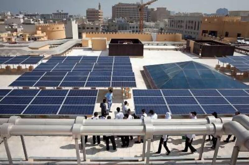 Pupils from Dubai's Jumeirah Baccalaureate School tour the solar photovoltaic system on the roof of the new Fahidi Market. The panels harness sunlight and use it to produce electricity and hot water. Silvia Razgova / The National