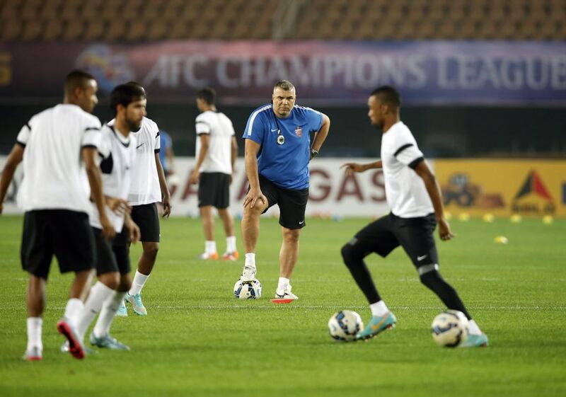 Al Ahli manager Cosmin Olaroiu watches his players train for their AFC Champions League final match against Guangzhou Evergrande on November 20, 2015. (AFP PHOTO)