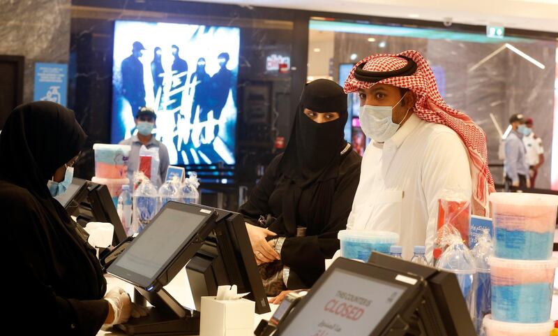 Saudi movie viewers wear face masks to help curb the spread of the coronavirus, as they buy refreshments at VOX Cinema hall in Jiddah. AP Photo