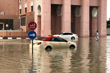 Cars in Dubai's Ibn Batutta Gate wait for pick-up trucks after breaking down in the water. James O'Hara / The National