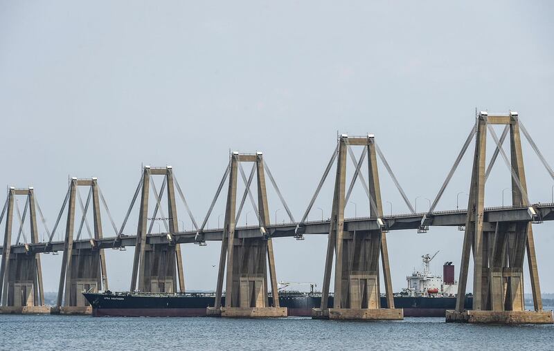 An oil tanker sails under the General Rafael Urdaneta bridge over the Maracaibo Lake in Maracaibo, Venezuela on March 15 , 2019. Production cutbacks by OPEC nations are building a supply cushion that could be called upon to mitigate a possible supply shock from an abrupt drop in crisis-hit Venezuela's output, the International Energy Agency (IEA) said Friday. / AFP / JUAN BARRETO
