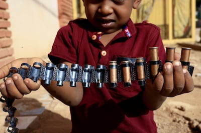A boy holds bullet cartridges as clashes between Sudan's paramilitary Rapid Support Forces and the army continue, in Khartoum. Reuters