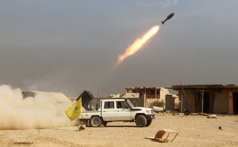 Iraqi Shiite fighters fire a rocket during a military operation against ISIS as they advance towards the centre of Baiji, about 200 kilometres north of Baghdad, on October 19, 2015.