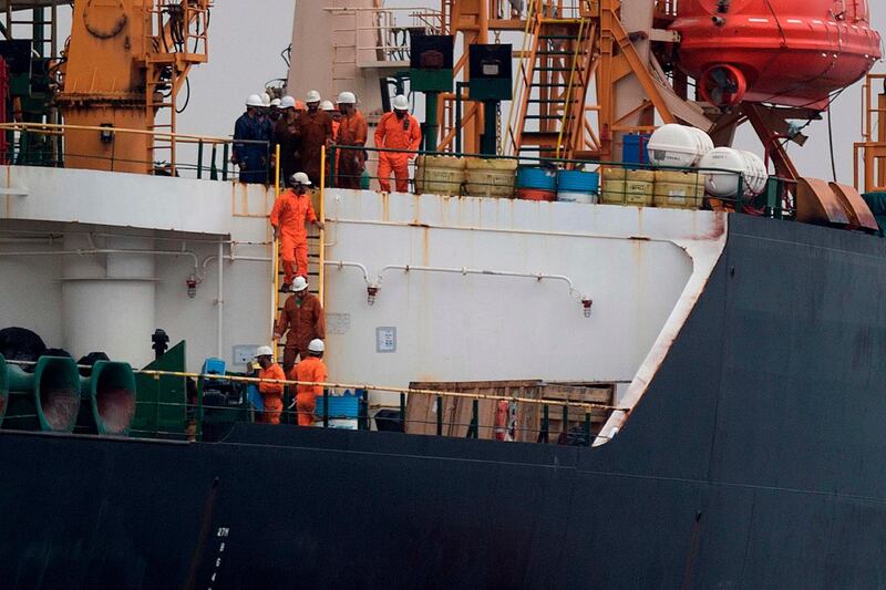 Crew members walk down a ladder on board supertanker Grace 1 off the coast of Gibraltar.  AFP