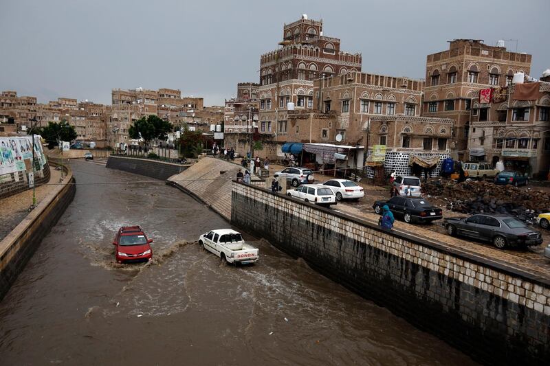 Vehicles drive through a flooded street following heavy rains in the old quarter of Sana'a, Yemen.  EPA