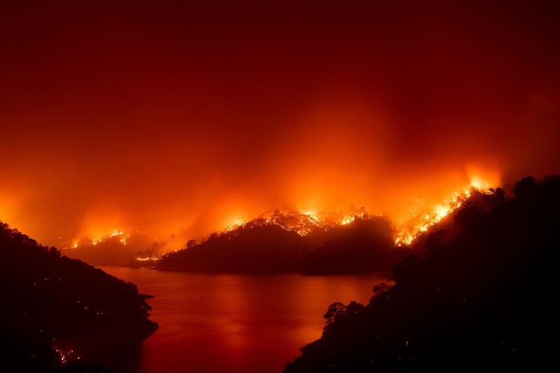 Flames from the LNU Lightning Complex fires burn around Lake Berryessa in unincorporated Napa County on Wednesday, August 19, 2020. Fire crews across the region scrambled to contain dozens of wildfires sparked by lightning strikes. AP Photo