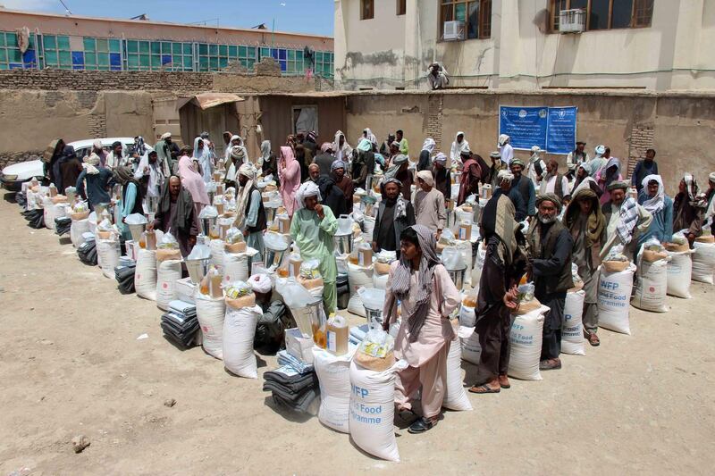 Afghan people receive their aid ration distributed by UN Refugee Agency (UNHCR) and World Health Organization (WHO) to people in need on the occasion of Ramadan, in Kandahar, Afghanistan.  EPA
