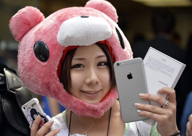 A young Japanese woman poses with her new iPhone 6. Franck Robichon / EPA